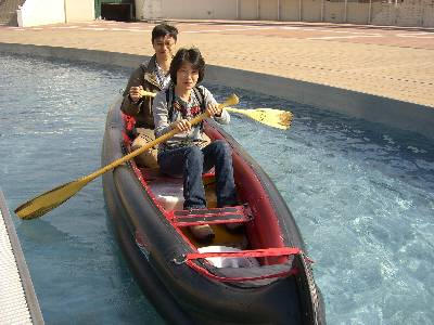 ボートのアトラクションに乗る奥村と妻
