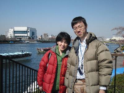 川を背景に記念写真に納まる奥村と妻