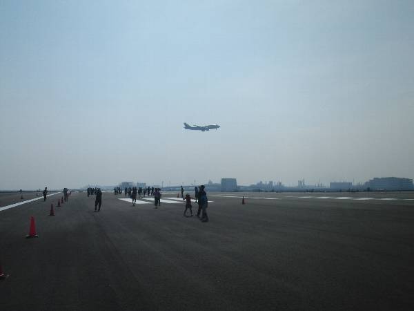 A (16L) 滑走路へ着陸していく機体と D (05/23) 滑走路を歩く人々